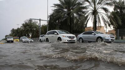 Drivers negotiate a flooded road in Abu Dhabi. Ravindranath K / The National