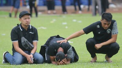 Arema FC players and officials react as they visit Kanjuruhan Stadium. Reuters