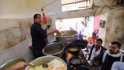 Yemeni customers buy cokked food at a market in the capital Sanaa's old city, on February 25, 2020. / AFP / Mohammed HUWAIS