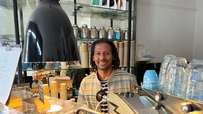 Anteneh Mulu, 46, poses behind the counter after serving a customer at his coffee shop. AP Photo