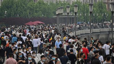 People wearing face masks visit the promenade on the Bund along the Huangpu River during a holiday on May Day, or International Workers' Day, in Shanghai. AFP