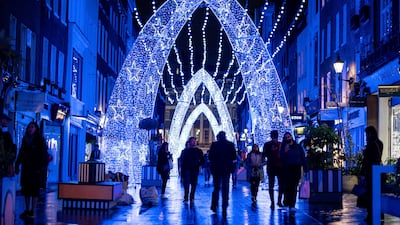 People walk among Christmas lights on South Molton Street, London.