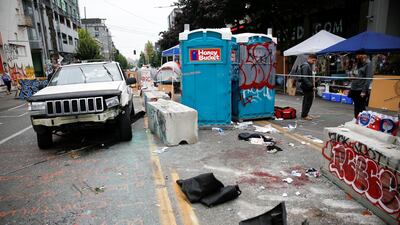 A car with several broken windows and a broken bumper sits at the Capitol Hill Organised Protest area after involvement in a fatal shooting. Reuters
