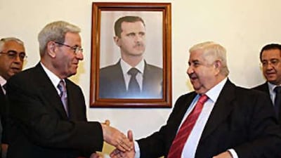 The Syrian foreign minister Walid Muallem (right) and his Lebanese counterpart Fawzi Salloukh shake hands after signing an agreement to restore diplomatic relations between the two countries in Damascus.