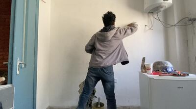 A young Syrian refugee works as a painter in Jordan. Like many young people who fled Syria, he was unable to finish his education. Amy McConaghy / The National