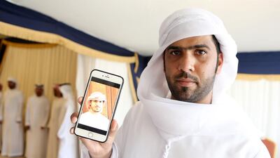 Abdullah Obaid Bin Fadel displays a photo of his brother Saeed Obaid Bin Fadel who was killed in Yemen on Friday at a tent set up by his family to receive condolences in Umm Al Quwain. Pawan Singh / The National