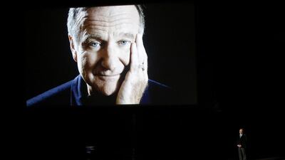Billy Crystal takes the stage to pay tribute to the late Robin Williams, shown on a large screen, during the 66th Primetime Emmy Awards in Los Angeles, California on August 25, 2014. Mario Anzuoni / Reuters