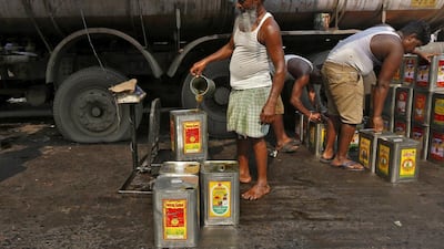 Nizamuddin, 60, pours cooking oil into tins as he weighs them at a wholesale market. Nizamuddin said he has lived in Kolkata for a long time but has no shelter. He uses plastic sheets to take shelter from rains and from the chill in winter. He wishes there were night shelters for workers like him.