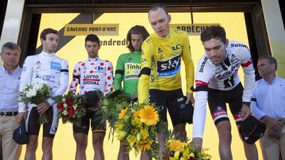 Left to right: Britain’s Adam Yates, Belgium’s Thomas de Gendt, Peter Sagan of Slovakia, Britain's Chris Froome, and stage winner Netherlands’ Tom Dumoulin lay flowers after observing a minute of silence to commemorate the victims of the Nice truck attack on the podium after Stage 13 of the Tour de France on July 15, 2016. (AP Photo/Peter Dejong)