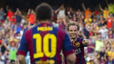 Ivan Rakitic celebrates with teammate Lionel Messi after s coring in Barcelona's 6-0 La Liga win over Granada on Saturday. Alejandro Garcia / EPA / September 27, 2014