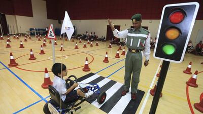 Rayyan Ramtoola, 6, gets the green light from Dubai Police officer Salahdeen Mohammed to proceed on the simulation road after waiting at the traffic signal at Gems Royal Dubai School. Sarah Dea / The National