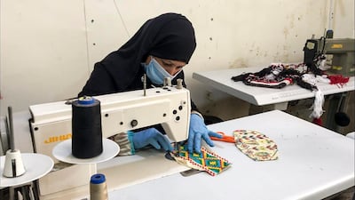 PPE is worn by the women while crafting the masks, and they are washed before they are sold on. AFP