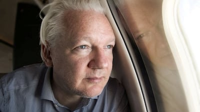 Mr Assange looks out of a plane window as he approaches Bangkok for a stopover. Reuters