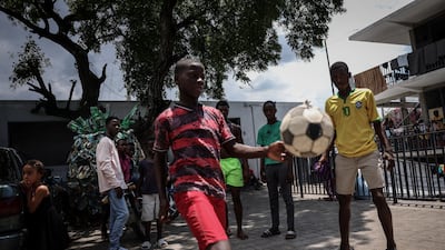 Children displaced by gang war violence play football at Argentine Bellegarde National School