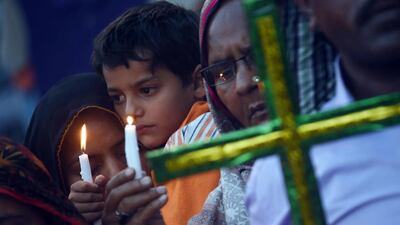 Pakistani Christians hold candles as they stage a rally in Lahore. AFP / ARIF ALI