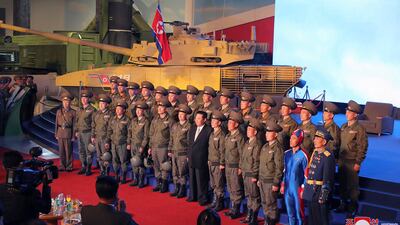 North Korean leader Kim Jong Un, centre, poses with military personnel – including the man in the super-tight blue outfit – at the opening of an exhibition of weapons systems in Pyongyang, North Korea. AP