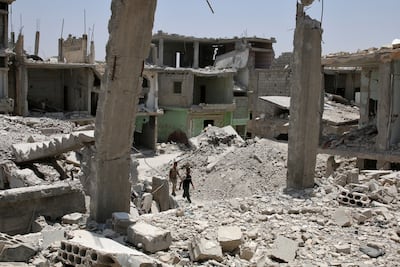 Men walk over rubble of damaged buildings in the province of Deraa, Syria. Reuters