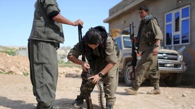 A PKK fighter adjusts a machinegun in preparation to join others near a site hit by ISIL car bombs in Sinjar. Asmaa Waguih / Reuters
