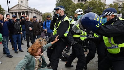 A woman falls as police move in to disperse protesters in Trafalgar Square in London, at a 'We Do Not Consent!' mass rally against vaccination and government restrictions designed to fight the spread of the coronavirus, including the wearing of masks and taking tests for the virus. AFP