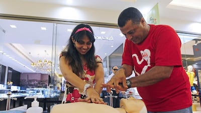 Sally Samy and Boubaker Beltaief, an instructor in CPR, during a lesson at a Sharjah mall organised by Go Red for Women. Jeffrey E Biteng / The National