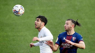 Real Madrid's Marco Asensio under pressure from Gaston Silva of Huesca. Reuters