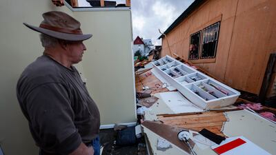 Mel Gilmer surveys the damage to his business in Selma. AP