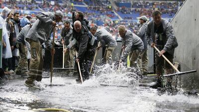 Workers clear water away prior to the Uefa Euro 2016 group E preliminary round match between Belgium and Italy at Stade de Lyon in Lyon, France, 13 June 2016. Sergey Dolzhenko / EPA