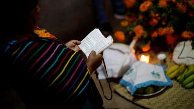 A woman prays in front of an altar in homage to a person who died recently. Reuters