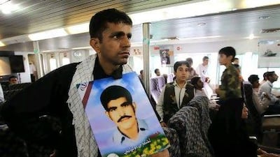 An Iranian man holds a portrait of his brother who was killed when a US warship shot down Iran Air flight 655 in 1988.