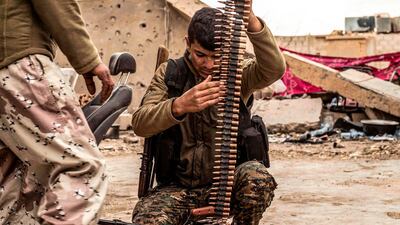 A fighter of the US-backed Syrian Democratic Forces loads an ammunition belt at a position in the village of Baghouz near Syria's border with Iraq. AFP