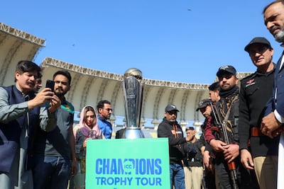 Fans take photos of the Champions Trophy during a ceremony at the Arbab Niaz Cricket Stadium in Peshawar, Pakistan, February 6, 2025. Reuters