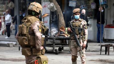 Iraqi soldiers close down a street during curfew as a part of precautionary measures against the spread of Covid-19 in central Baghdad. EPA