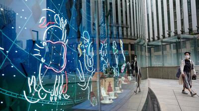 A person wearing a mask walks past a show window at Ginza shopping district in Tokyo, Japan. EPA