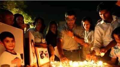 Mourners attend a vigil at St Mary's Catholic Church in Dubai for Nathan D'Souza, 5, and sister Chelsea, 7, who died after eating at a cafeteria in the emirate in 2009. Officials had ruled out food poisoning.