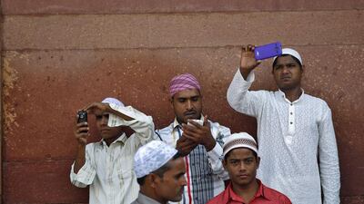 Muslims use their mobile phones after offering Eid al-Adha prayers at the Jama Masjid (Grand Mosque) in the old quarters of Delhi. Ahmad Masood / Reuters
