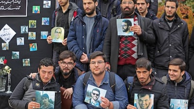 Students hold pictures of victims during a memorial for the passengers of the Ukraine plane crash in University of Tehran. AFP
