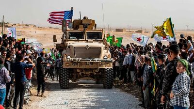 Syrian Kurds gather around a US armoured vehicle during a demonstration against Turkish encroachment. AFP