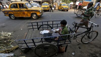 Rahul Shaw, 10, reads a textbook in his father's rickshaw before he goes to school. Shaw said he studies in a government-run school that gives him free meals. He wants to become a doctor and treat people for free.