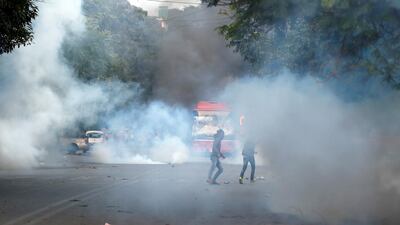 Demonstrators run for cover as smoke billows from a tear gas shell fired during a protest against a new citizenship law in New Delhi, India, December 15, 2019. Picture taken December 15, 2019. REUTERS/Adnan Abidi