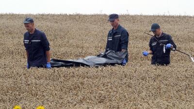 Ukrainian rescue workers carry the body of a victim on a stretcher through a wheat field at the site of the crash of Malaysia Airlines plane MH17 that was shot down on Thursday. Emergency workers say that rebels have removed the bodies from the crash site. Dominique Faget/AFP Photo