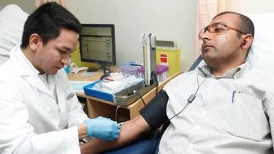 Esmail Abdol Ghader, a 36-year-old Iranian, donates his type O blood as nurse Mark Anthony Torres Lagonera applies an anaesthetic at Al Wasl Hospital.