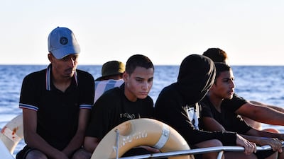 Tunisians trying to flee to Europe sit aboard a Tunisian coast guard vessel after being intercepted at sea on August 10, 2023. AFP