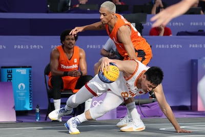 China's Zhang Ning falls to the floor while Worthy de Jong stands over him, in the men's pool round 3x3 basketball game at Paris 2024. AFP