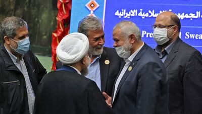The leader of the Palestinian Hamas movement, Ismail Haniyeh, shakes hands with Iran's outgoing president Hassan Rouhani.