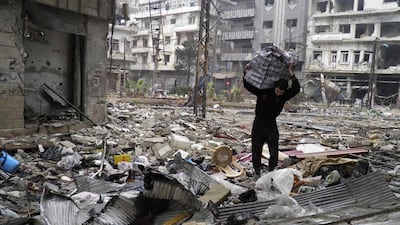 A man carries a bag amid damage and debris in the besieged area of Homs on January 26, 2014. Thaer Al Khalidiya/Reuters