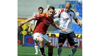 Roma's Francesco Totti fends off the challenge of Cagliari's Daniele Magliocchetti.