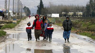 Syrian refugees walk along a makeshift settlement in Bar Elias in the Bekaa valley on January 5, 2015. Mohamed Azakir/Reuters