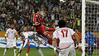 Iran's Mohammad Gholami's shot at goal hits the crossbar, next to United Arab Emirates' Walid Abbas (No 14).