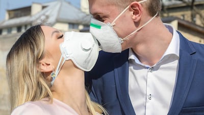 Lithuanian groom Dainius and his bride Ramune pose for the photographer, wearing protective masks against the new coronavirus after their wedding ceremony in Vilnius, Lithuania. AFP