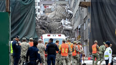 Emergency workers in Mexico City arrive at the scene of a collapsed building, where at least four people have been trapped. EPA